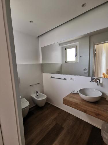 a bathroom with two sinks and two toilets at Hotel Onda Marina in San Teodoro