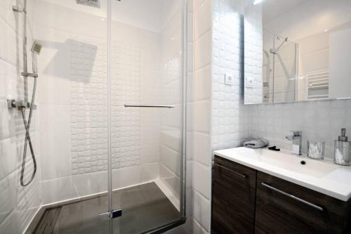 une salle de bain blanche avec une douche et un lavabo dans l'établissement LA CIOTAT - Magnifique Appartement climatisé sur le Port, à La Ciotat