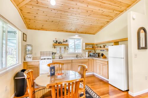 a kitchen with a table and chairs and a refrigerator at Kahu 'lo - Guardian Hawk in Volcano