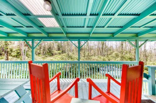 two red chairs sitting on a porch with a blue ceiling at Kahu 'lo - Guardian Hawk in Volcano