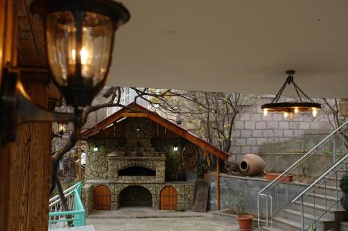a house with a stone fireplace in a yard at Guest House Anahit Ijevan in Ijevan