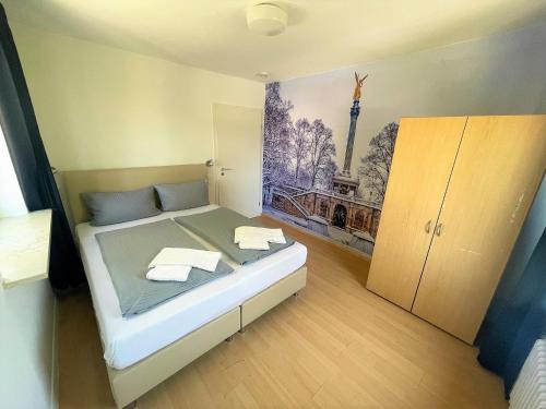 a bedroom with a bed with a painting on the wall at Olympia Pension in Dachau