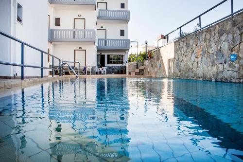 a swimming pool in front of a building at Popi Hotel Apartments in Agia Marina Nea Kydonias