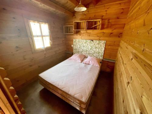 Domaine du vieux chêne في برجراك: سرير صغير في كابينة خشبية مع نافذة