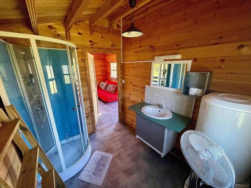 een badkamer met een wastafel en een douche in een blokhut bij Domaine du vieux chêne in Bergerac