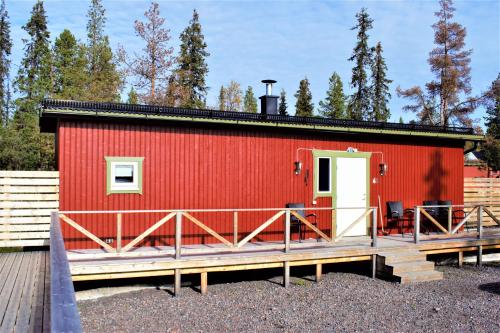 a red tiny house with a wooden deck at Camp Alta Kiruna in Kiruna
