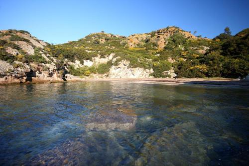 a body of water with a beach and mountains at Locazione Turistica da Placida in Suni