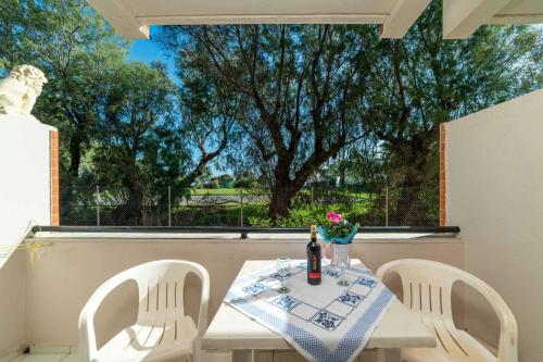 a table with two chairs and a bottle of wine at Troulis Seaside in Amoudara Herakliou