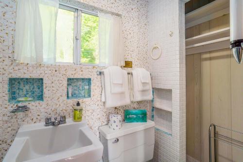 a bathroom with a sink and a toilet and a window at Grandma's Sandbox in Beulah