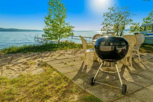a grill sitting on a table next to the water at Grandma's Sandbox in Beulah