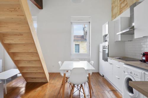 eine Küche mit einem weißen Tisch und einer weißen Arbeitsplatte in der Unterkunft Charming flat nearby Garonne river - Bordeaux - Welkeys in Bordeaux
