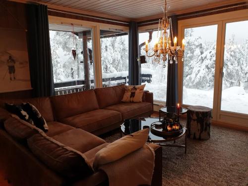 a living room with a couch and a chandelier at Solhytta Fantastisk beliggenhet! Hytte til leie på Skrim! in Kongsberg