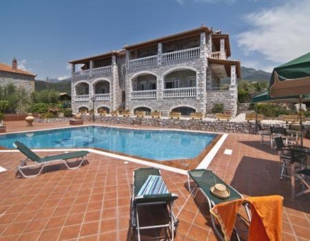 a house with a swimming pool in front of a building at Amalia Apartments in Stoupa