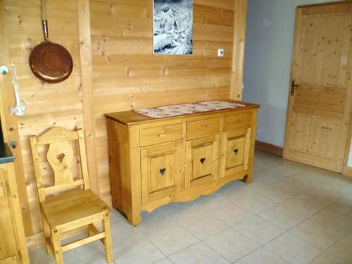 Cette chambre comprend une armoire en bois et une chaise. dans l'établissement Appartement familial à Notre-Dame-de-Bellecombe 80 m² avec jardin, à Notre-Dame-de-Bellecombe