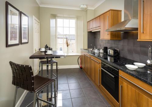 cocina con mesa y encimera en Old Town Suites - Nicolson en Edimburgo