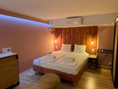 a bedroom with a large bed with a wooden headboard at Black Swan House, Old Town in Gdańsk