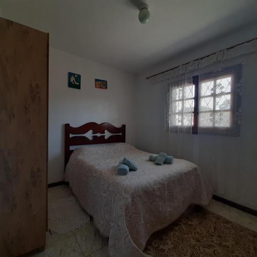 a bedroom with a bed with two pillows on it at Casa Quintanilha in Campos do Jordão