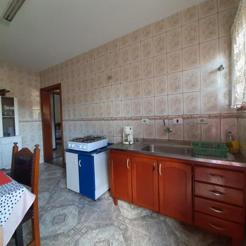 a kitchen with a sink and a counter top at Casa Quintanilha in Campos do Jordão