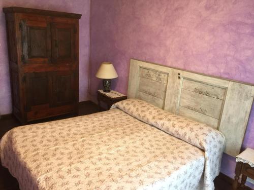 a bedroom with a bed and a wooden door at A REALDO - Casa Il Nido Delle Aquile in Triora
