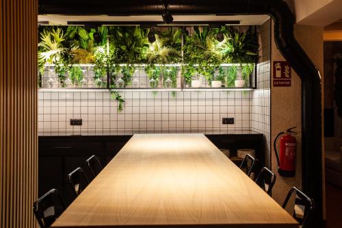 a long table in a room with plants on the wall at Hospedium H Cabo Sport in Finisterre