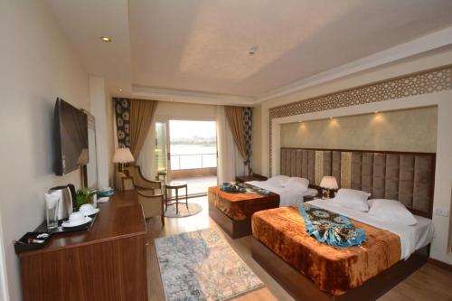 a hotel room with two beds and a television at Nile Transport Hotel in Cairo