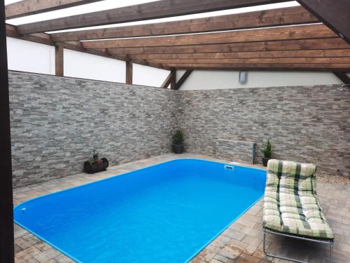 an indoor swimming pool with a brick wall and a blue pool at Rodinný pension U Soudku in Rudník