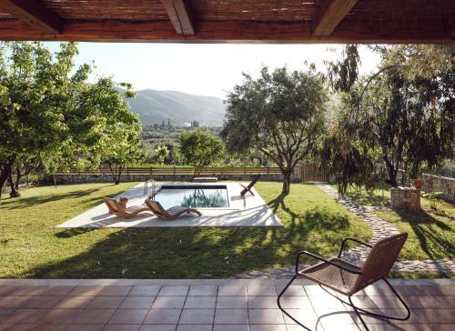 un patio con 2 sillas y una piscina en Leeda's Cottages, en Lithakia