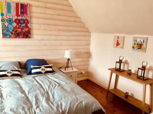 une chambre avec un lit et un mur en bois dans l'établissement TY JACQ, à Tréguennec