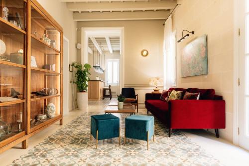 a living room with a red couch and blue stools at Hotel Boutique Can Sastre in Ciutadella