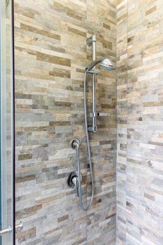 a shower in a bathroom with a stone wall at Bacco e Barocco in Lecce