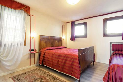 1 dormitorio con 1 cama con colcha roja en Prosecco hills, 1 hour from Venice, swimming pool, ground floor, en Miane