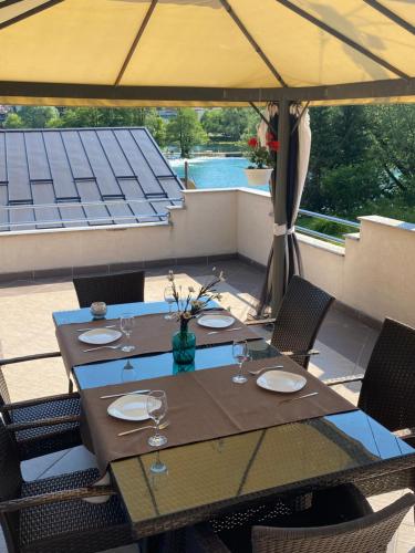 a table with chairs and an umbrella on a patio at Apartman River Una in Bihać