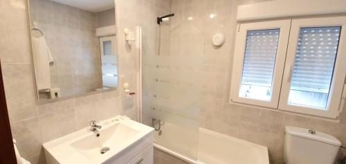 Baño blanco con lavabo y aseo en Hotel La Quinta, en Cue