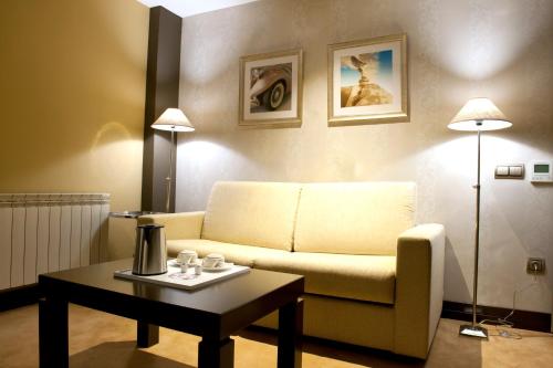 a living room with a couch and a coffee table at Costa Esmeralda Suites in Suances