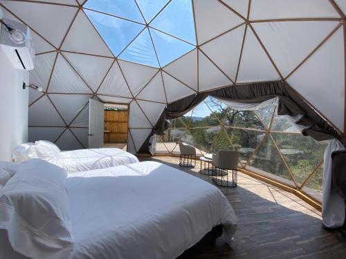 um quarto com uma cama grande numa tenda em COSMOS GLAMPING ARTEAGA em Arteaga