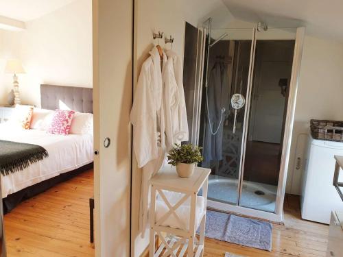 a bedroom with a bed and a glass shower at QUAI 3 loft moderne et lumineux les pieds dans l'eau in Jarnac