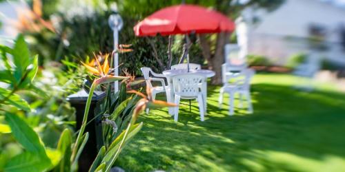 two white chairs and an umbrella in a yard at Comfortable apartment in Capitana 50 sqm, sea view, garden in Capitana