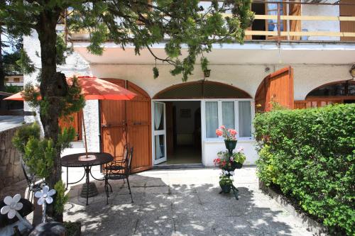 a patio with a table and chairs and a building at Green Riviera Case Vacanza in Borzonasca