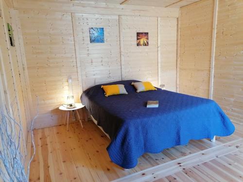 a bedroom with a bed in a wooden cabin at LE PRE DE L AIR in Saint-Michel-Mont-Mercure