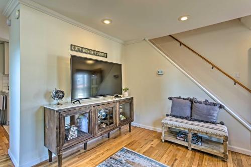 a living room with a television and a stair case at Updated Home with Patio Half Mile to West Point in Highland Falls