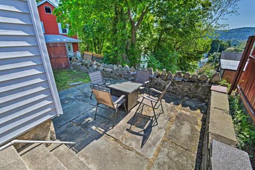 a patio with chairs and a table and a stone wall at Updated Home with Patio Half Mile to West Point in Highland Falls