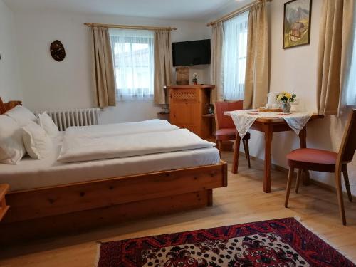 a bedroom with a bed and a table and chairs at Heilbad Burgwies in Stuhlfelden