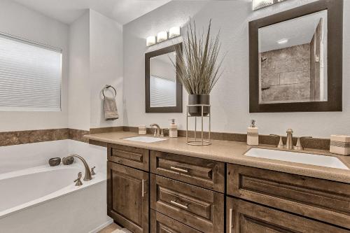 ein Badezimmer mit einer Badewanne, einem Waschbecken, einer Badewanne und einem Spiegel in der Unterkunft Sunset Ridge in Phoenix