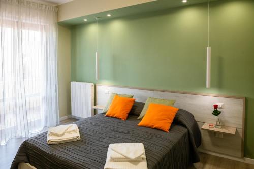 a bedroom with a large bed with orange pillows at Bacco e Barocco in Lecce