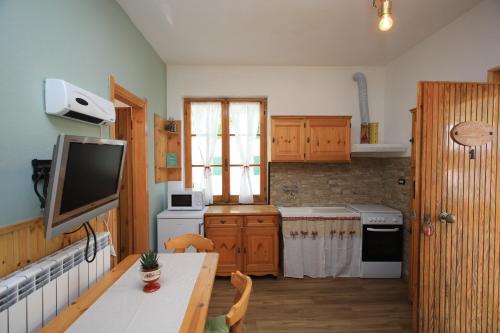 a kitchen with a table and a television in it at Green Riviera Case Vacanza in Borzonasca