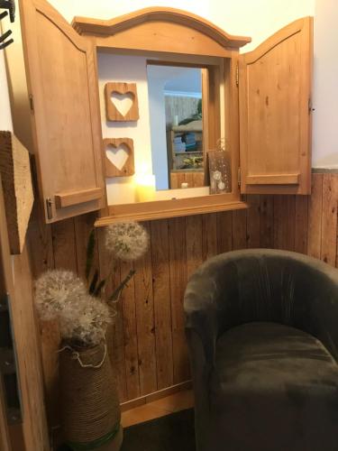a living room with a chair and a mirror at Zur neuen Post Landgasthof in Herzogsreut