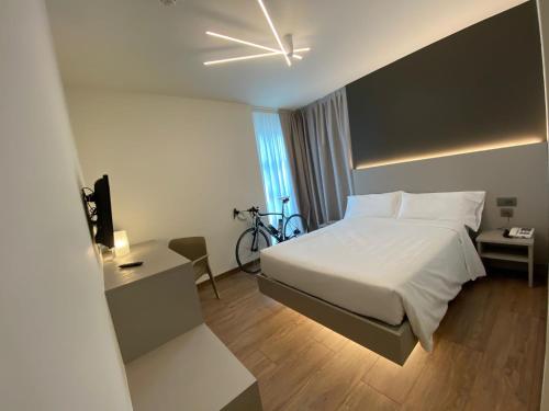 una habitación de hotel con una cama y una bicicleta. en Fly Bike Hotel en Trento