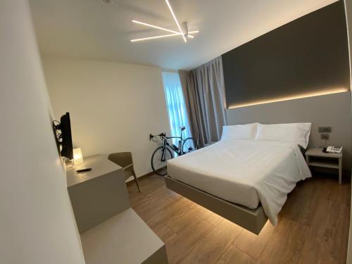 トレントにあるFly Bike Hotelのベッドと自転車が備わるホテルルームです。