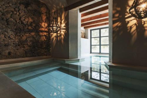 Nits de Bosc في Vilassar de Dalt: حمام سباحة داخلي مع أرضية زجاجية في المنزل