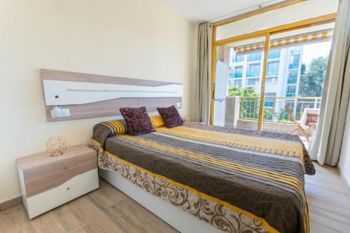 a bedroom with a bed and a large window at 2BD-Piscina-Playa-Port Aventura2 in Salou